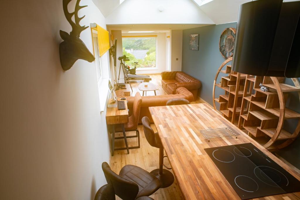 a living room with a table and chairs and a living room at Schoolhouse 1 Cottage by Fairy Pool in Carbost