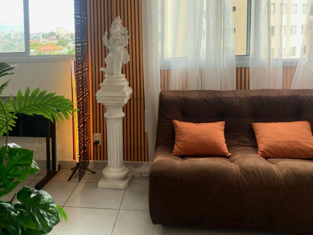 un salon avec un canapé et une colonne blanche dans l'établissement Studio Charmoso 2km do Aeroporto de Congonhas, à São Paulo