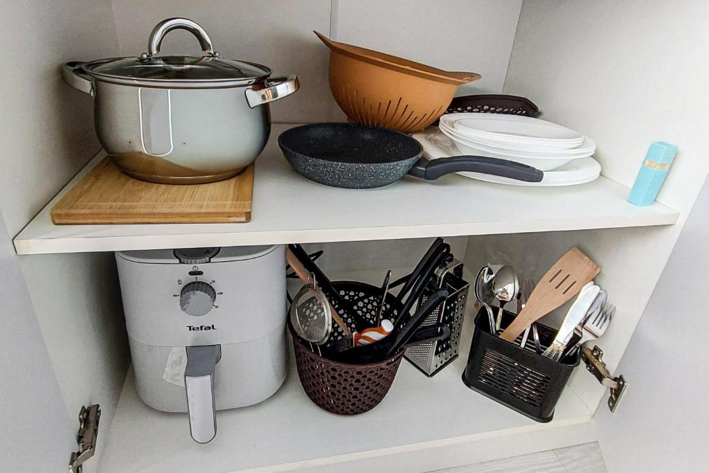 une étagère avec une marmite et d'autres ustensiles de cuisine dans l'établissement Апартаменти на Лисенка, à Dorotichi