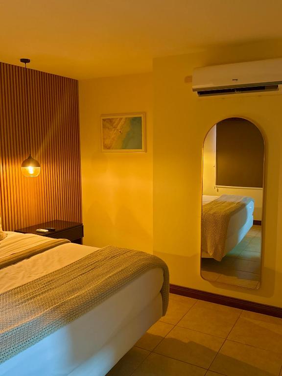 a hotel room with two beds and a mirror at Palmas de Tamarindo Resort, 304E in Guanacaste