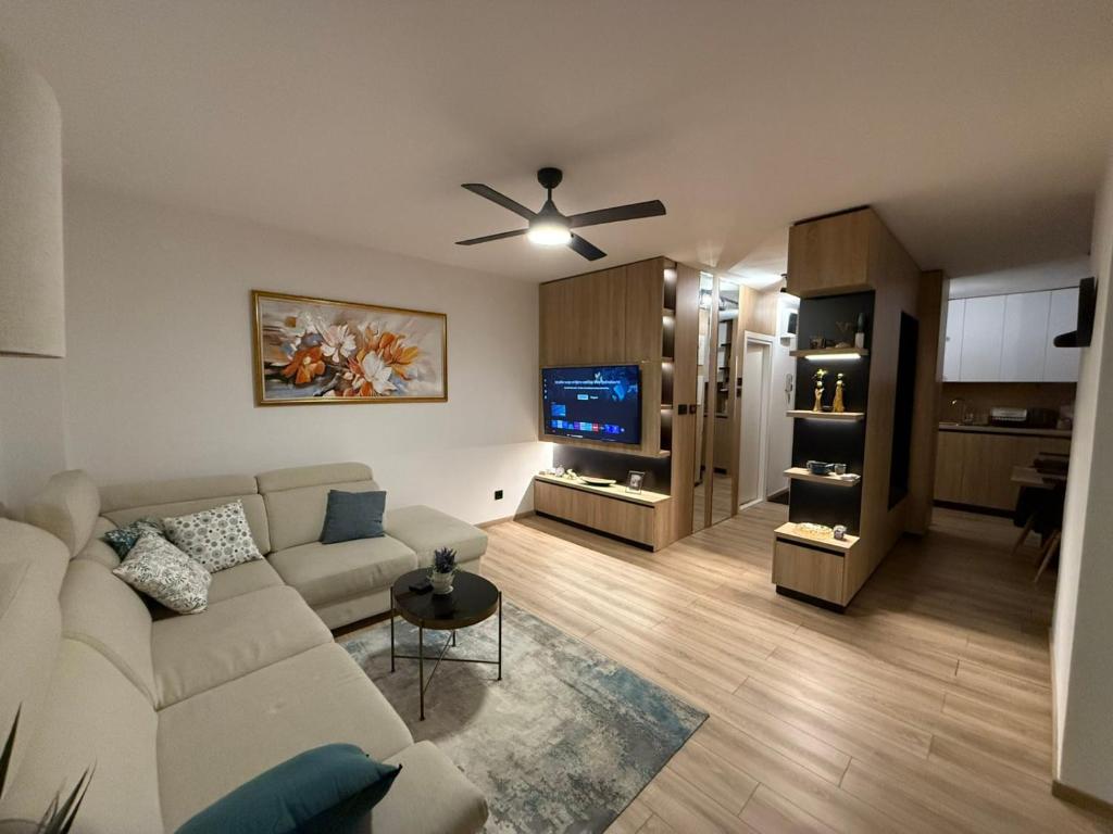 a living room with a white couch and a tv at Central Spot BL in Banja Luka