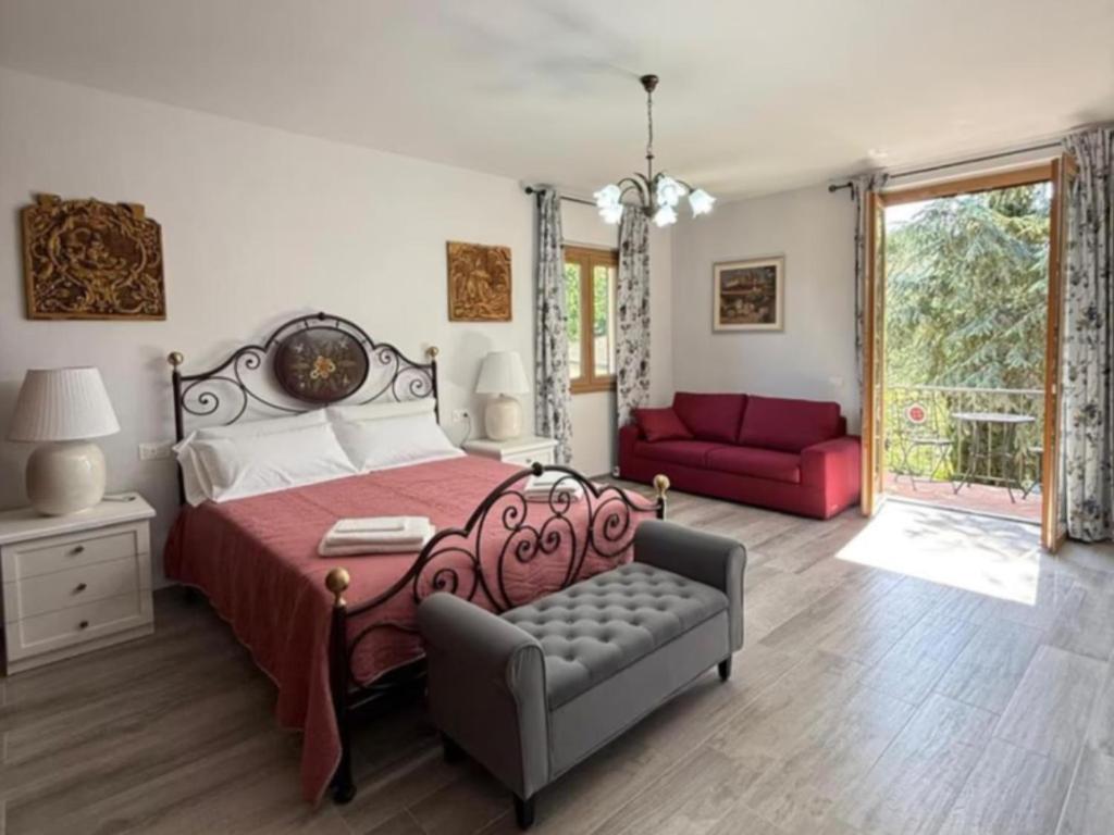 ein Schlafzimmer mit einem Bett und einer roten Couch in der Unterkunft Villa Casavecchia Caselli in Dicomano