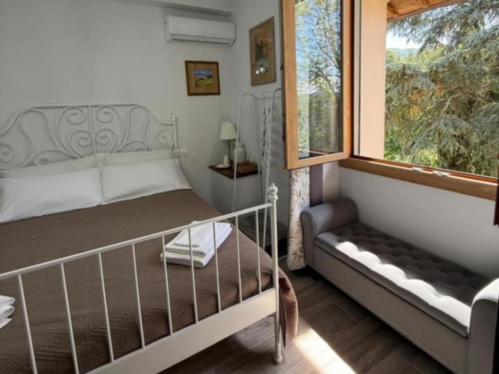 ein Schlafzimmer mit einem Bett und einem Fenster in der Unterkunft Charming Guest Room in Villa Casavecchia with City, Garden, and Mountain Views in Dicomano