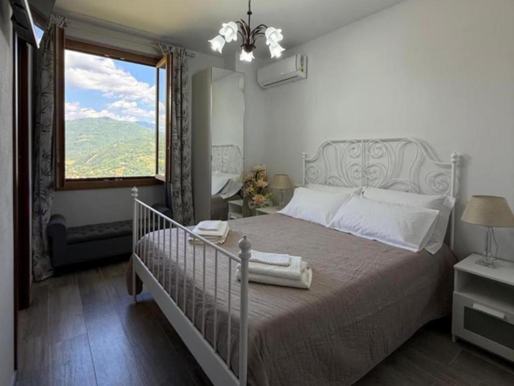 ein Schlafzimmer mit einem Bett und einem großen Fenster in der Unterkunft Charming Guest Room in Villa Casavecchia in Dicomano