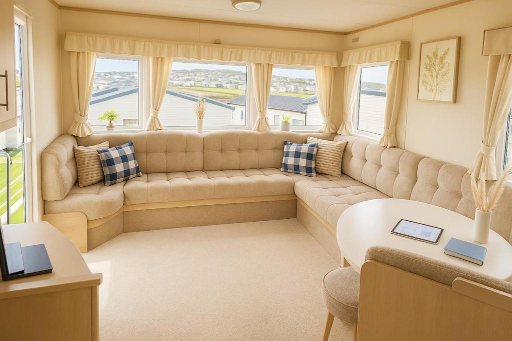 阿伯里斯特威斯Welsh Seaview Stay 3 bed caravan by pool, club and beach的带大沙发和窗户的客厅