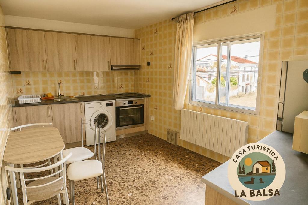 a kitchen with a table and chairs in a room at La Balsa in Matalebreras