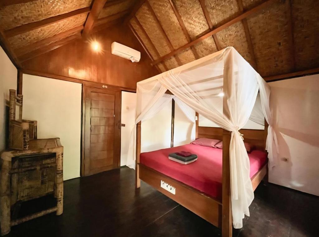 a bedroom with a bed with a canopy at UTOPIA in Gili Air
