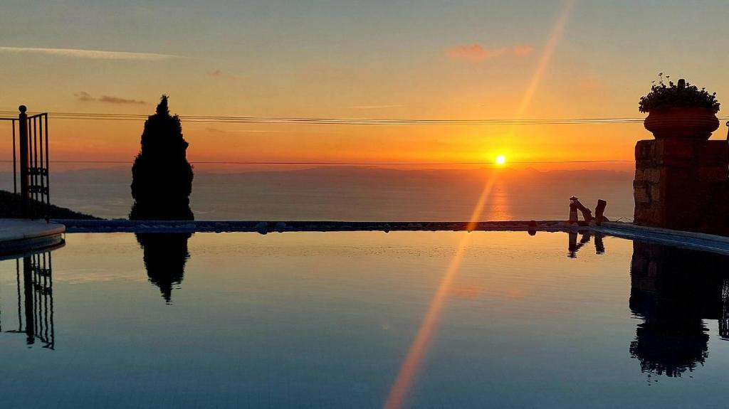 einen Infinity-Pool mit Sonnenuntergang im Hintergrund in der Unterkunft Four Seasons Stonework Castle in Lagonisi