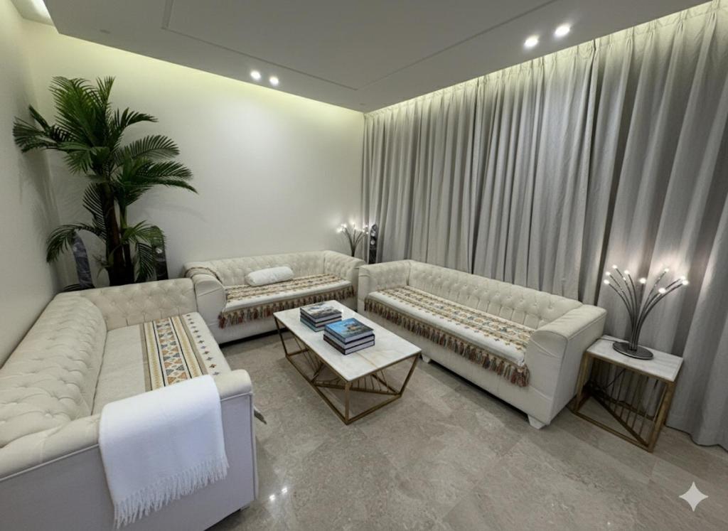 a living room with two couches and a table at 3BR 5Bed luxury apartment in Jeddah