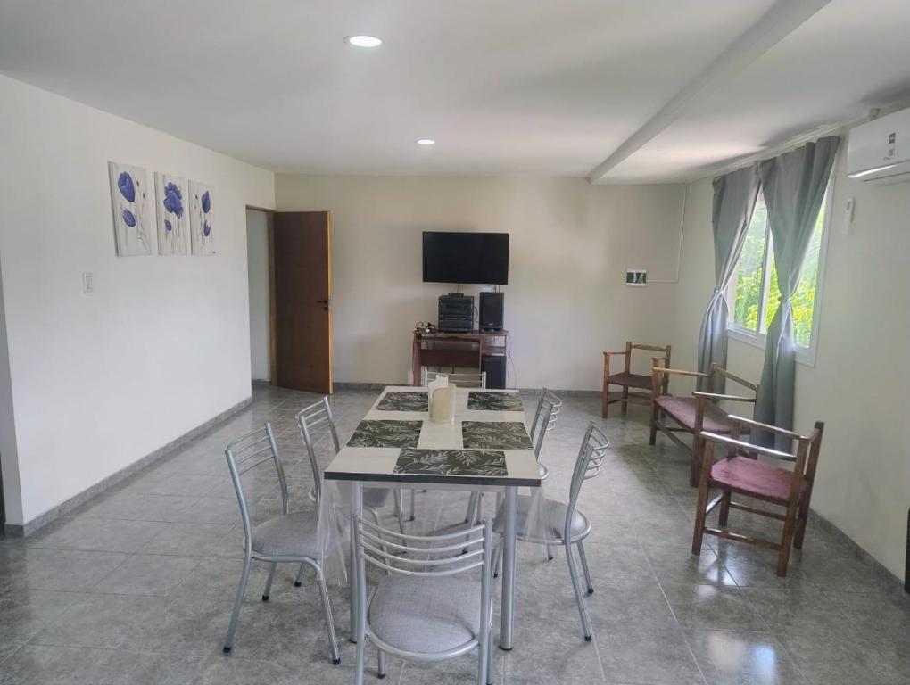 a dining room with a table and chairs and a tv at Apart Cuyo in San Rafael