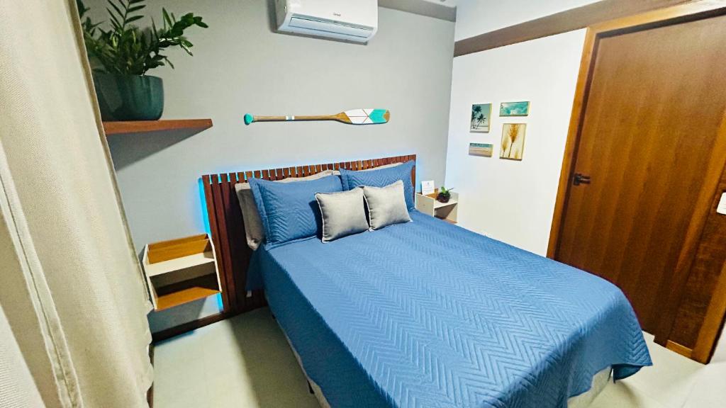 a bedroom with a bed with blue sheets and pillows at JanHouse Ilhabela in Ilhabela