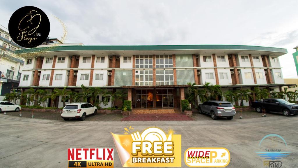 a building with cars parked in front of it at CJ by the Bay in Olongapo
