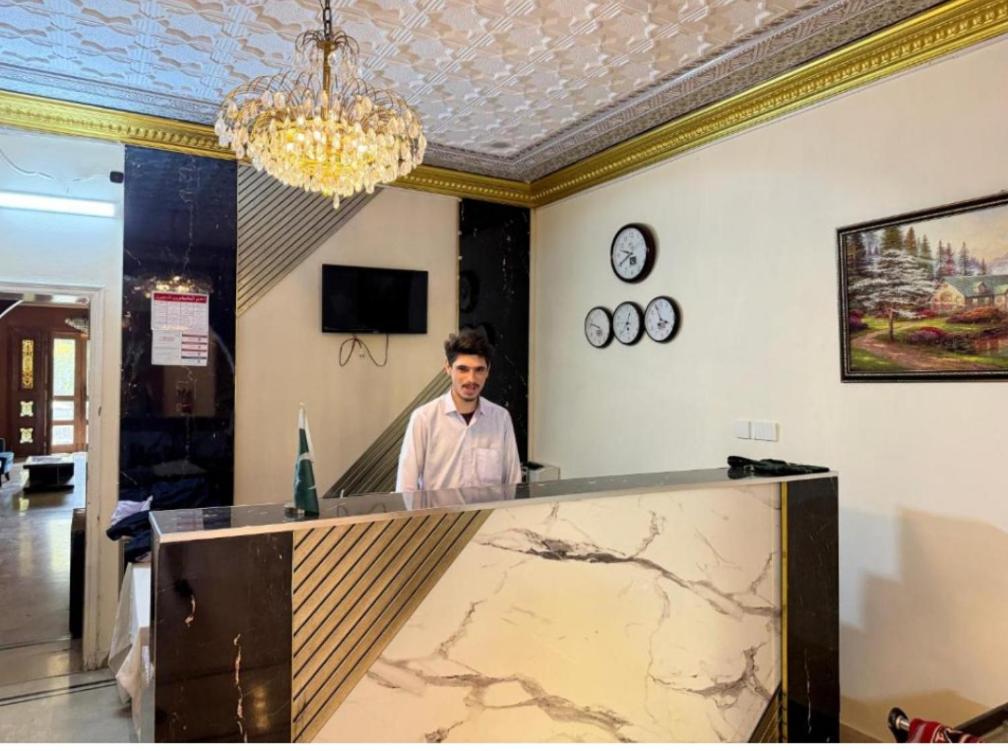 Un homme debout derrière un comptoir dans une pièce dans l'établissement Baani signature, à Islamabad