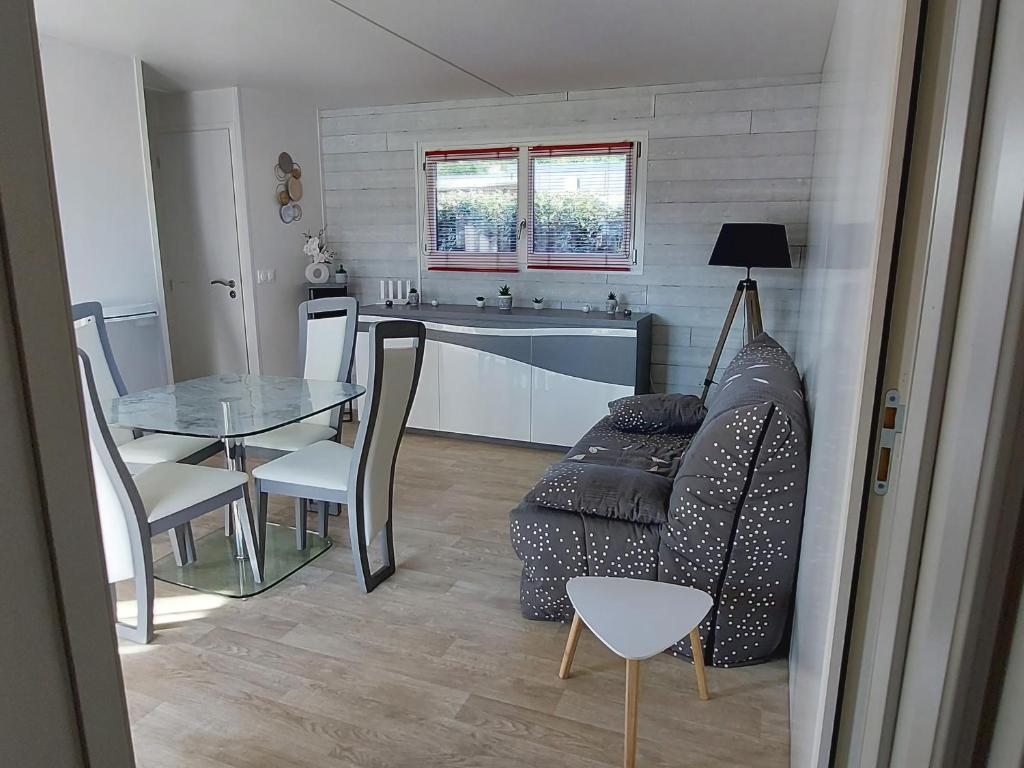 a living room with a table and a couch and a kitchen at chalet de 1 a 7 personnes in Hermanville-sur-Mer