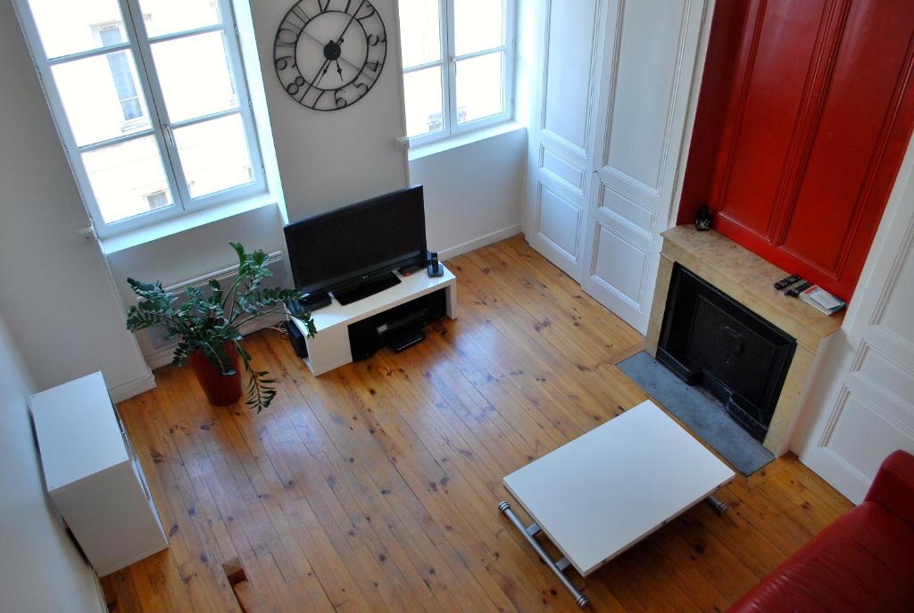 vistas panorámicas a una sala de estar con TV y chimenea en L'Appartement du Parc, en Lyon