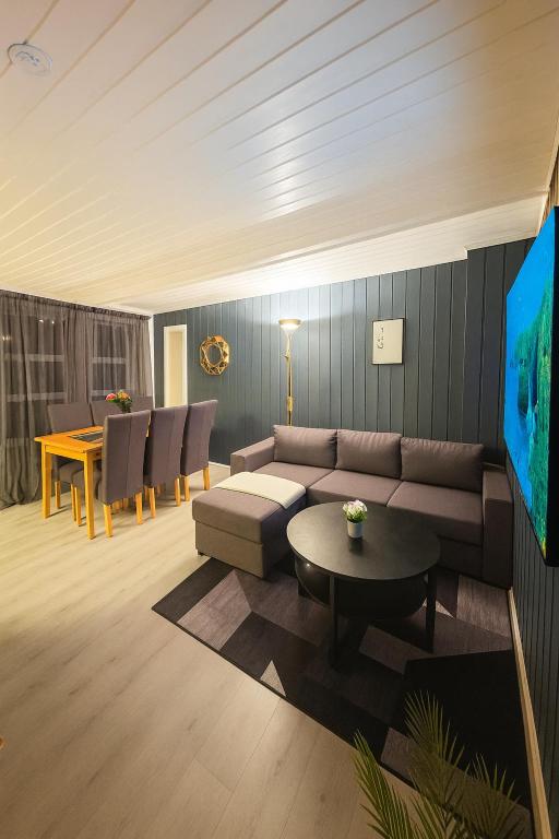 a living room with a couch and a table at Sentralt og elegant opphold nær alt in Lillehammer