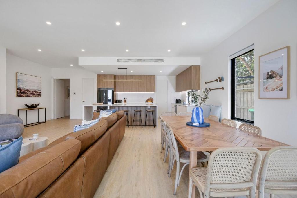 een woonkamer met een lange bank en een tafel bij Peninsula Sea Breeze in Safety Beach