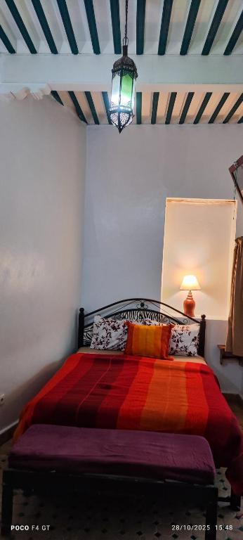 a bedroom with a bed with a colorful blanket at Dar darko in Essaouira