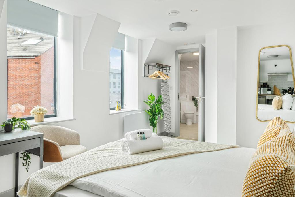 a white bedroom with a bed and a mirror at The City Pad in Nottingham