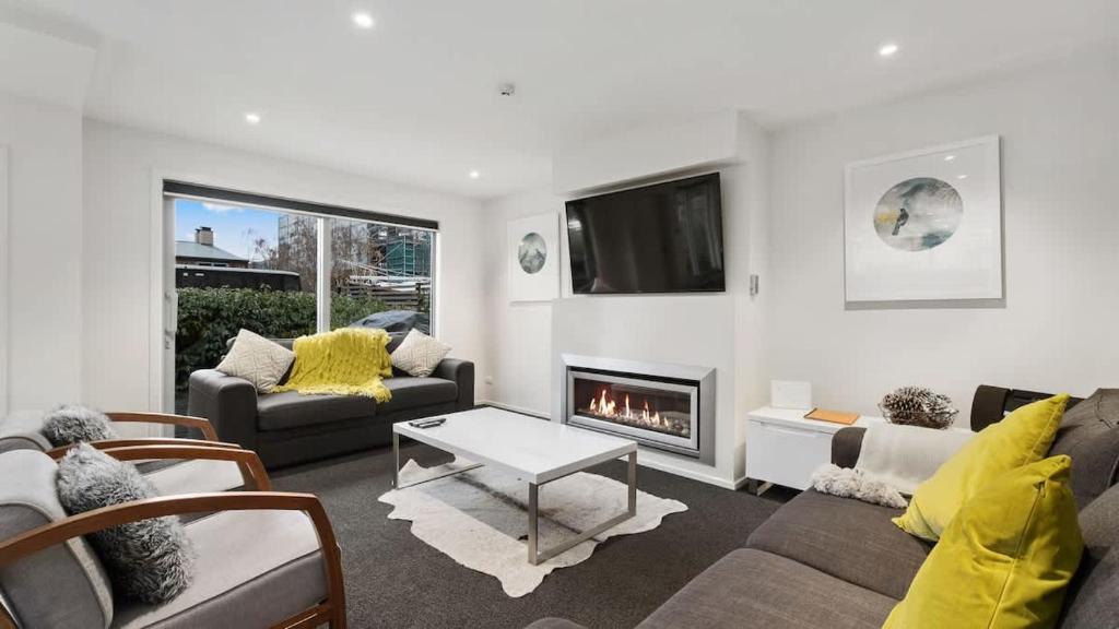 a living room with a couch and a fireplace at Diamond Luxury Central Queenstown in Queenstown