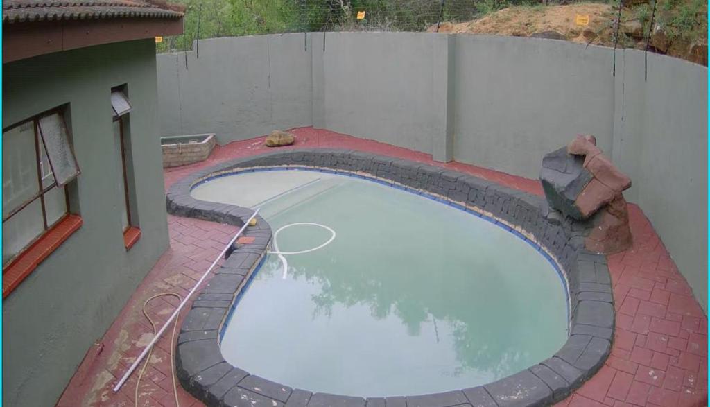 einen Blick über einen großen Pool auf ein Gebäude in der Unterkunft BTV Holiday Home in Hazyview