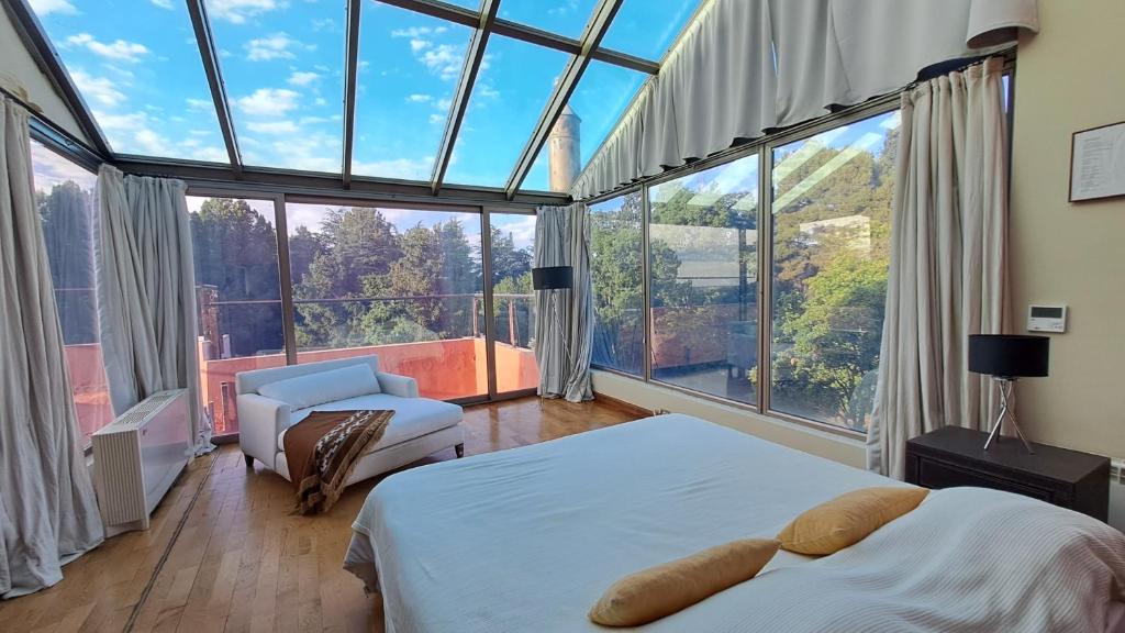 a bedroom with a bed and a large window at Casa de Campo Petit Lodge in Estancia Grande