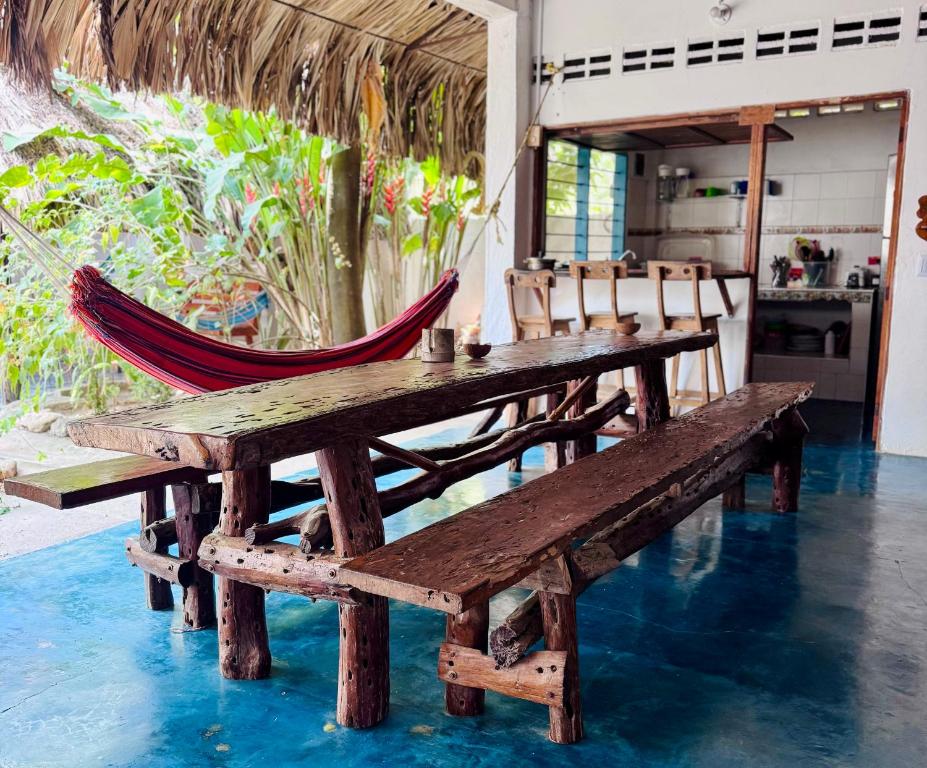 a hammock and a wooden table and chairs at Casa Surf Mar Azul in Palomino