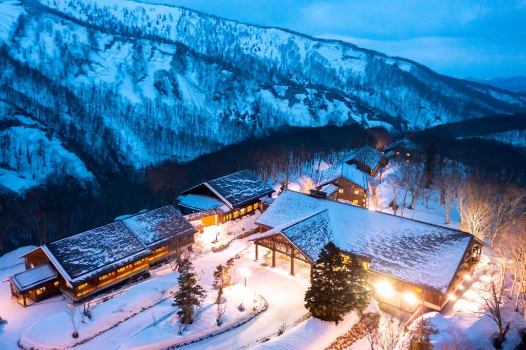 a lodge in the snow with a mountain in the background at Hakkoda Hotel in Aomori