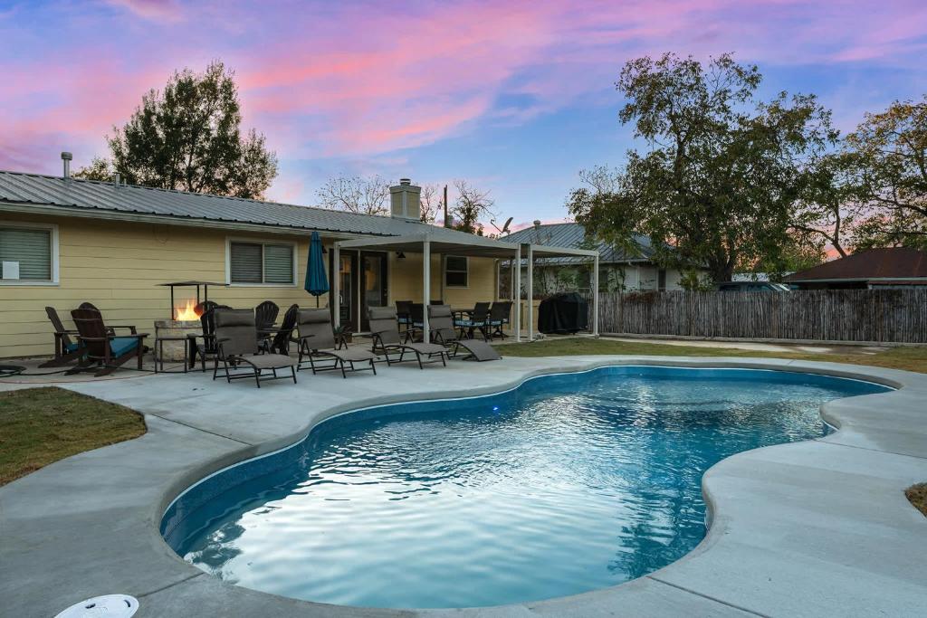 ein Swimmingpool vor einem Haus in der Unterkunft Porch & Pour - Hot Tub & Fire Pit in Fredericksburg