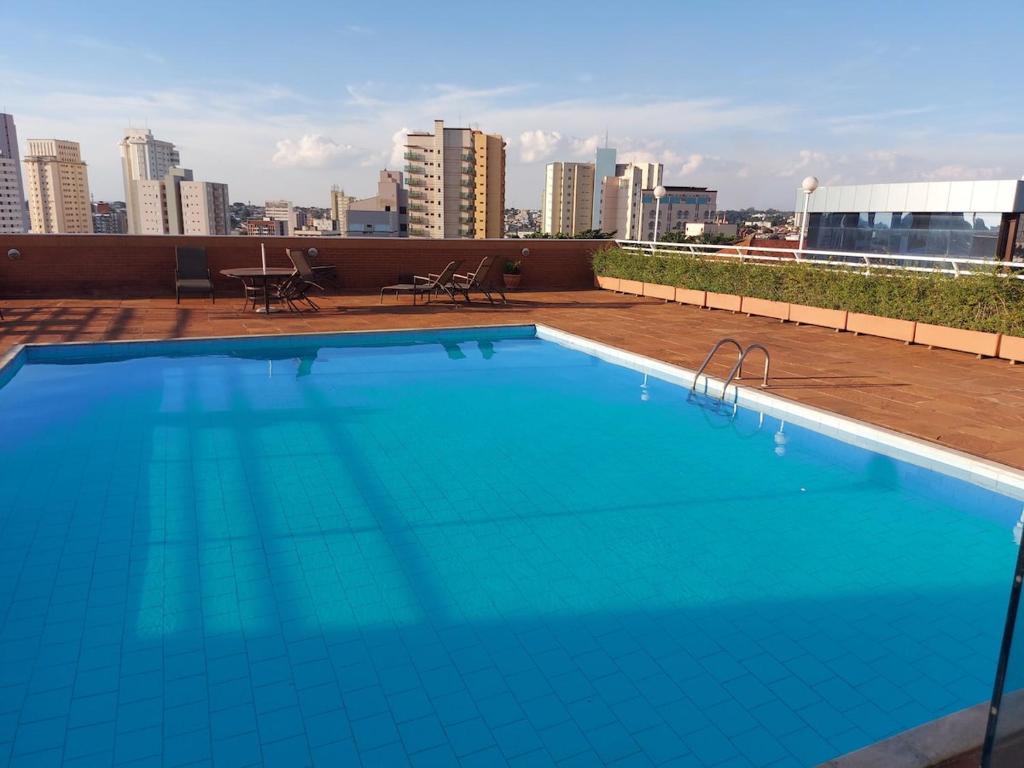a large blue swimming pool on top of a building at Flat com Piscina e Academia in Uberaba