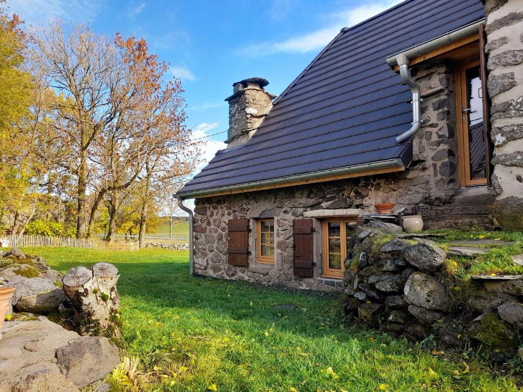 an old stone house with a black roof at Gîte rénové pour 4 pers. avec accueil équin, Saint-Front - FR-1-582-538 in Moudeyres