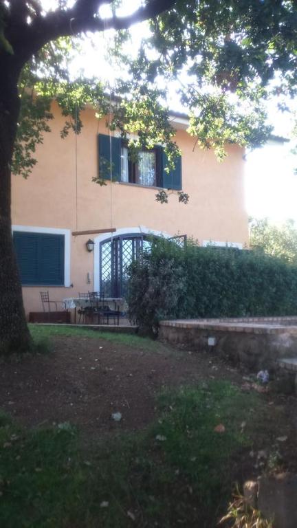 una casa con un árbol delante de ella en B&B Le Querce en Riano