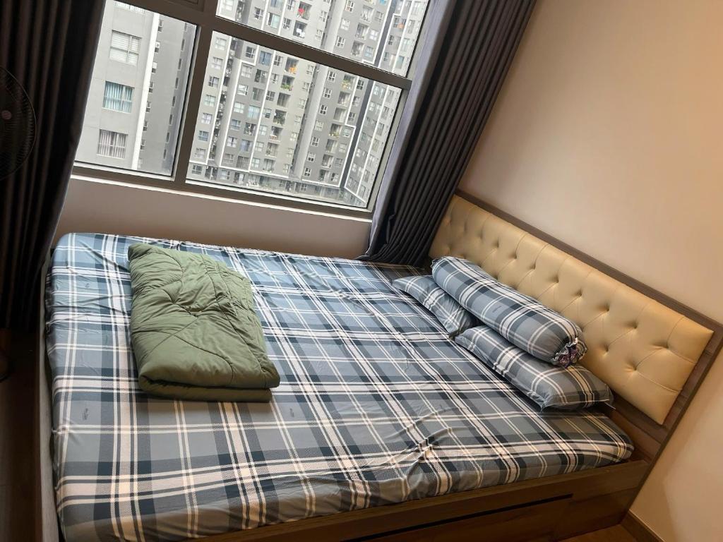 un letto con cuscini in una stanza con finestra di An's Home ad Ho Chi Minh