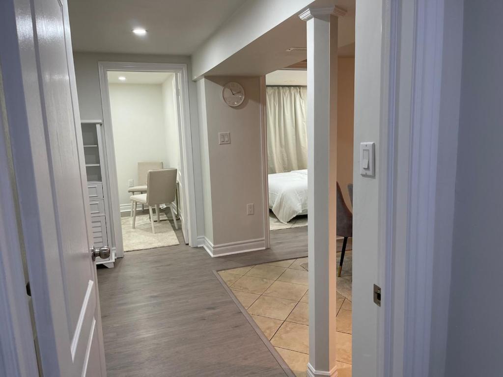 a hallway with a room with a bed and a table at Hanan Hospitality in Toronto
