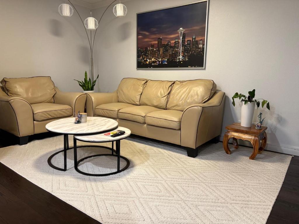 a living room with a couch and a table at Two fully independent unit - a modern house and a private apartment, each with its own entrance, located just 15 min from Sea-Tac Airport and 5 min from Des Moines Marina in Des Moines