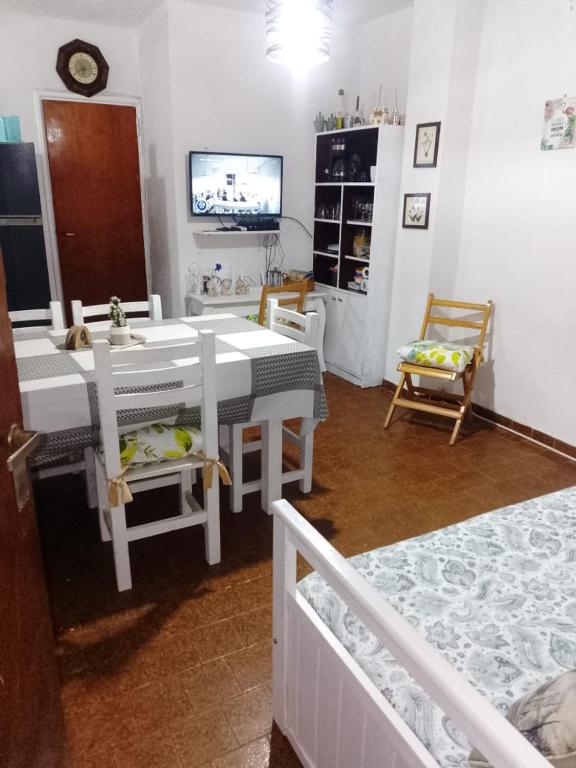 a living room with a table and chairs and a tv at Departemento Garay in San Bernardo