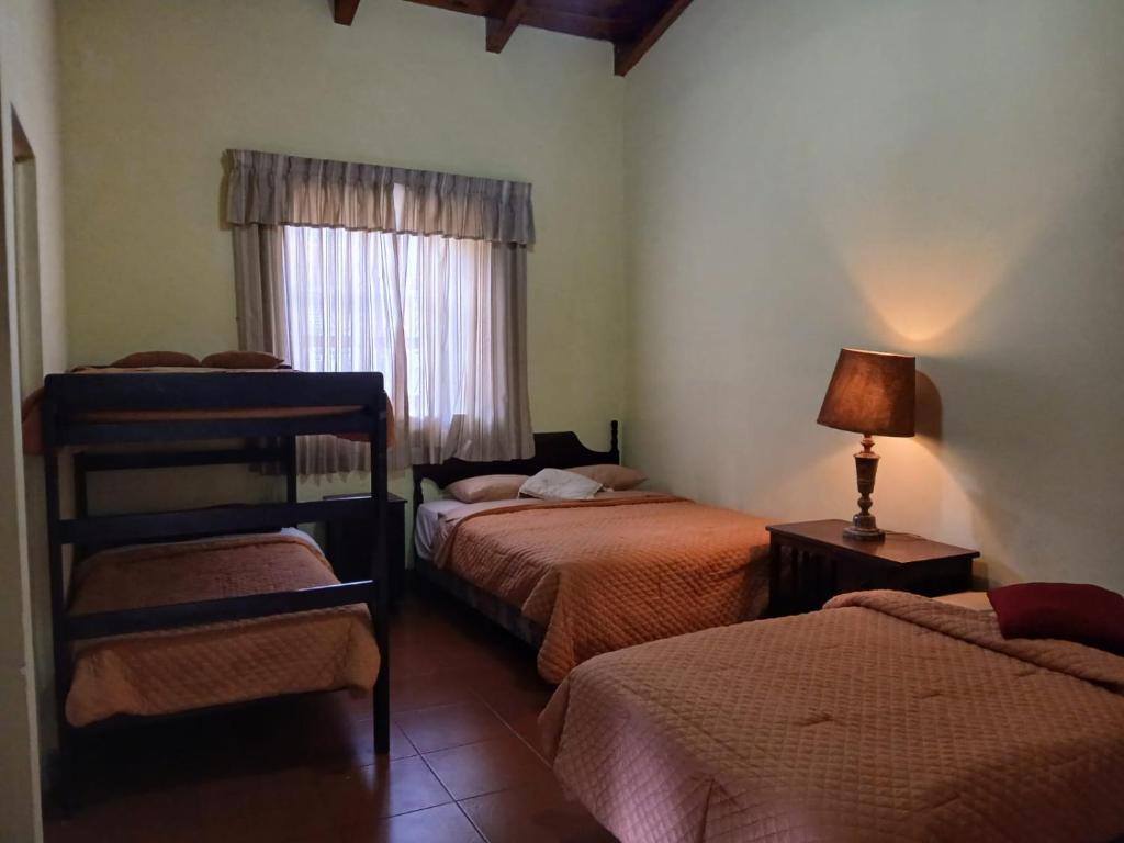 a bedroom with two beds and a window at Jardín de Los Sueños Quinta San Felipe in Antigua Guatemala