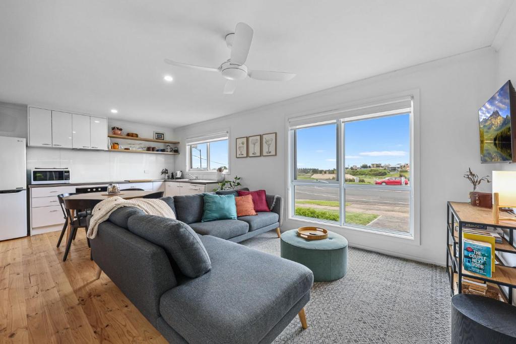 ein Wohnzimmer mit 2 Sofas und einer Küche in der Unterkunft The Bungalow in Warrnambool