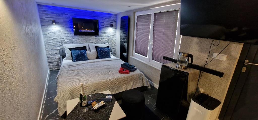 Una pequeña habitación con una cama y un televisor. en Jacuzzi przy Plaży - Apartament Kołobrzeg, en Kołobrzeg