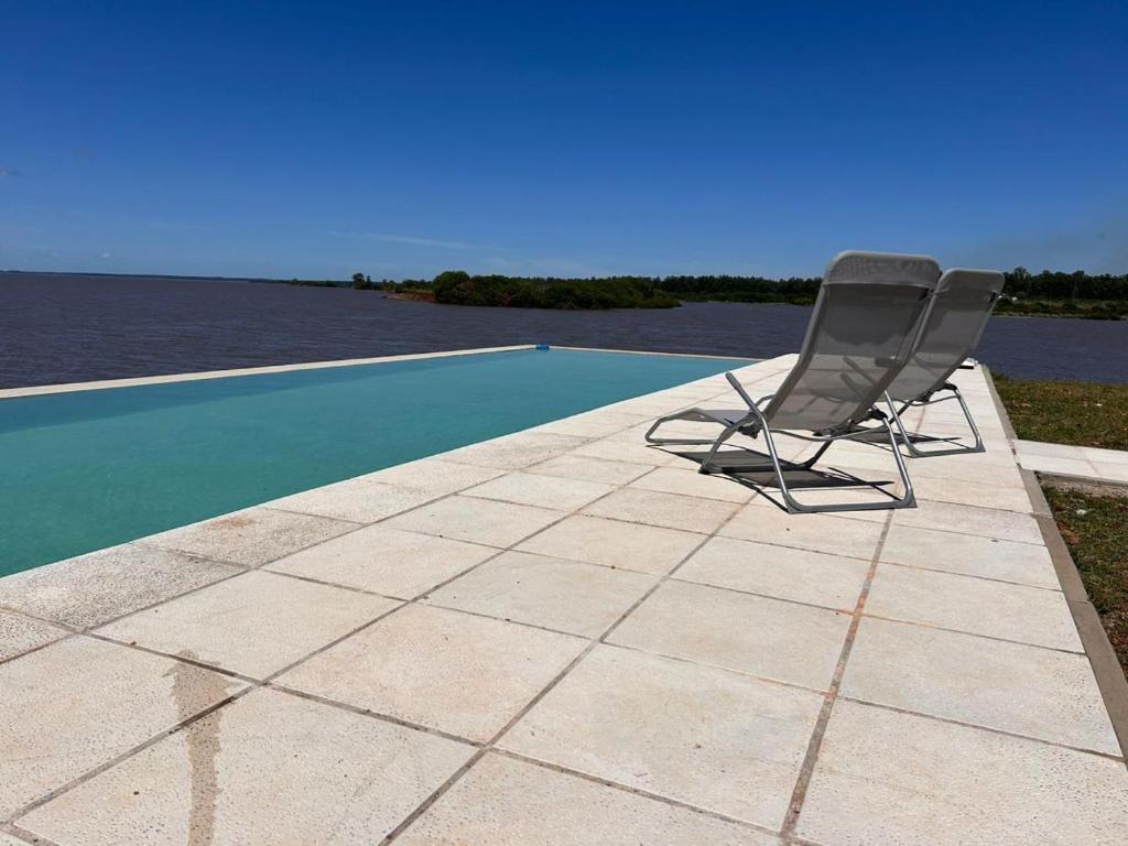 two chairs sitting on a patio next to a swimming pool at La moradaa in Federación