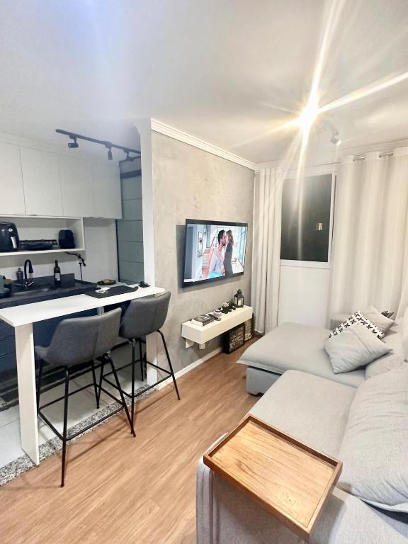 a living room with a white couch and a kitchen at 1706 -Lindo apartamento próximo Tietê e Anhembi in São Paulo
