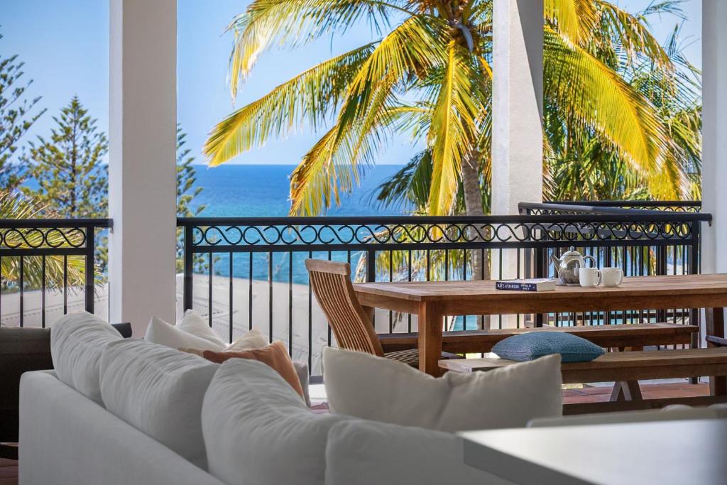 a living room with a white couch and a table at 3 Hilltop Villas White Water Views from the Heart of Sunshine in Sunshine Beach