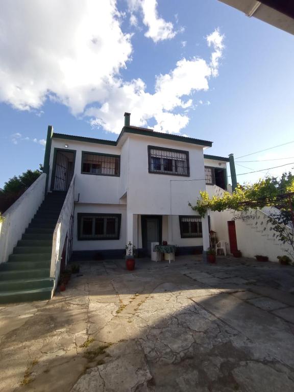 a large white house with a stairway in front of it at Hospedaje Santa Teresita in Santa Teresita