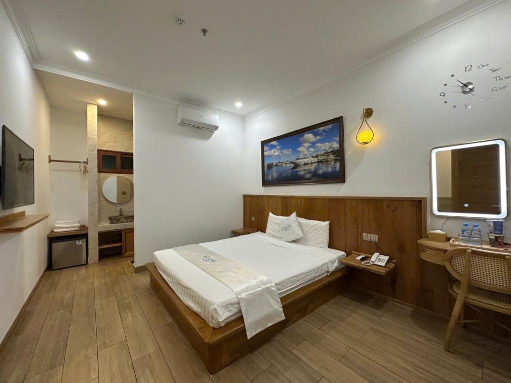 a bedroom with a bed and a desk and a tv at HOLIDAY HOTEL PHAN THiẾT in Ấp Bình Hưng