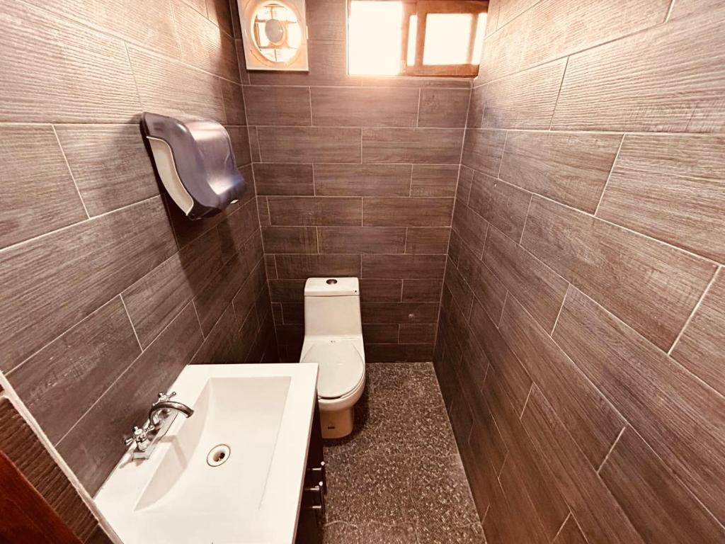 Un baño con lavabo blanco y inodoro. en Lartbook, en Monterrey