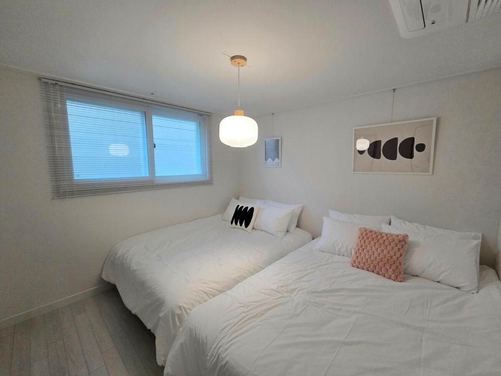 ein Schlafzimmer mit zwei Betten und einem Fenster in der Unterkunft 2 Bathrooms & 3 Rooms, New Elevator in Seoul
