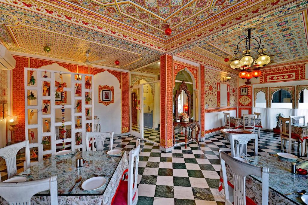 ein Esszimmer mit einem Tisch und einer Decke in der Unterkunft Hotel O Tordi Haveli in Jaipur