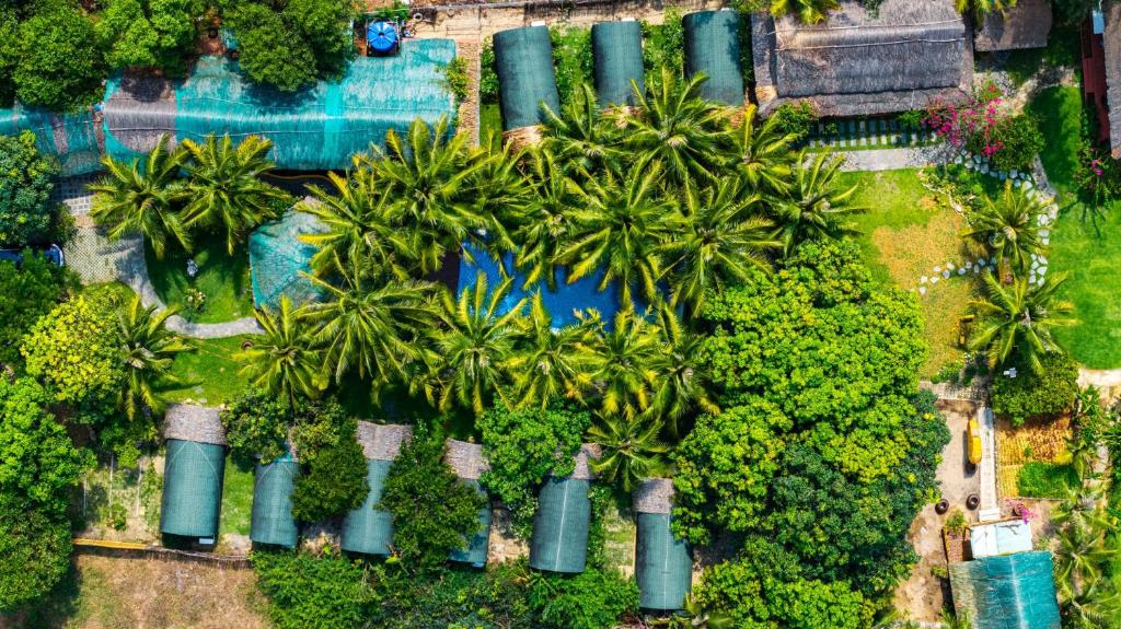eine Draufsicht auf ein Resort mit Palmen und einem Pool in der Unterkunft Hoianam Village in Thăng Bình