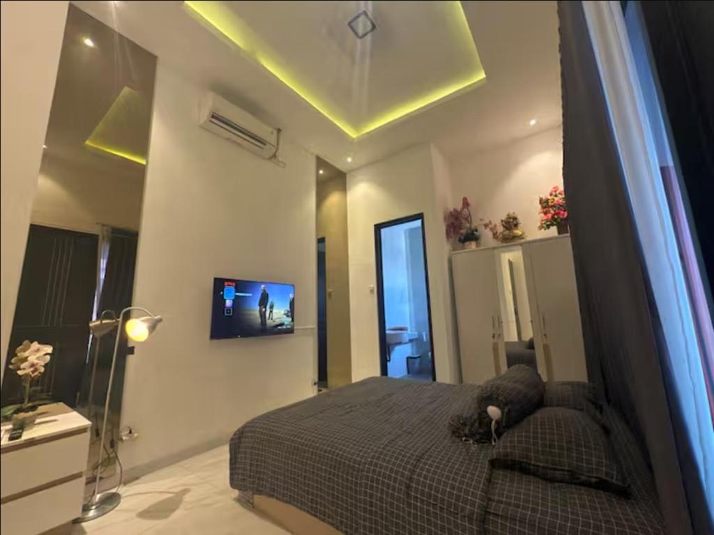 a bedroom with a bed and a tv on the ceiling at Villa Velare 01 Dharmahusada Indah Galaxy Mall in Surabaya