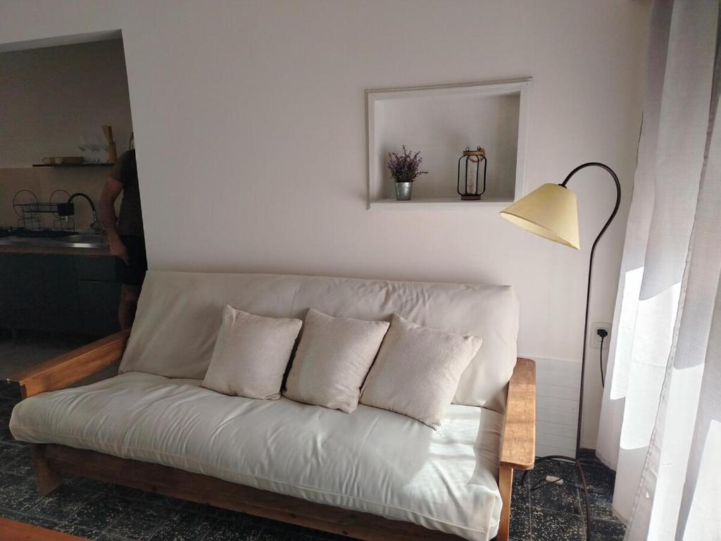a white couch in a living room with a lamp at Casa en el centro de Carmelo in Carmelo